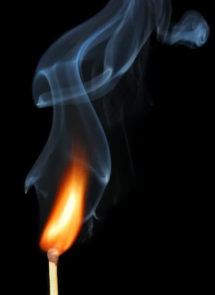 Brinnande tändsticka med rök på svart — Stockfoto