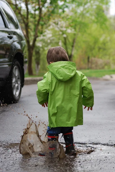 Small boy playing in puddles — Stock Photo, Image