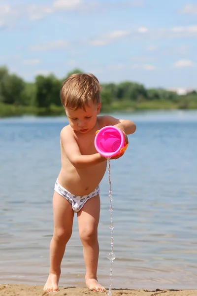 Küçük çocuk kumsalda oynuyor. Stok Fotoğraf