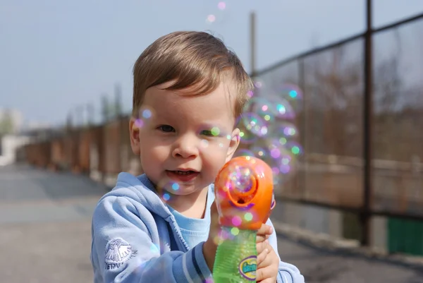 Liten pojke leker med såpbubblor Stockbild