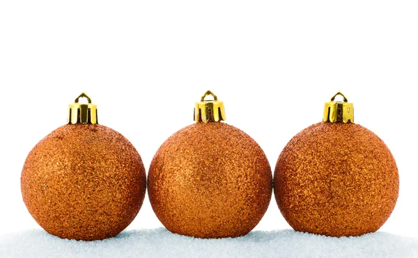Three golden christmas balls in a snow — Stock Photo, Image