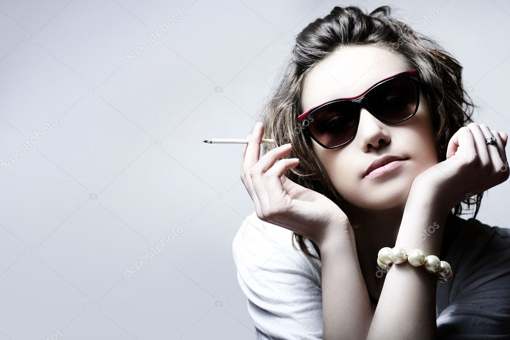 The beautiful girl smokes a cigarette