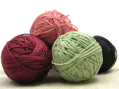 A few balls of wool on a beige backgrou clipart