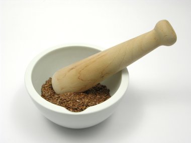 Pestling brown flaxseed in a bowl of chi clipart