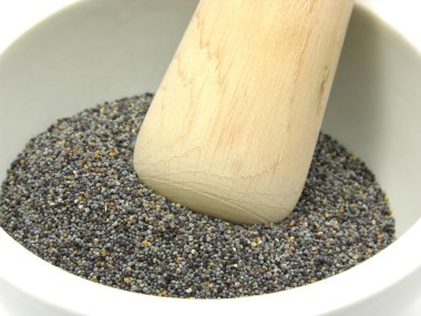 Pestling poppy seeds in a bowl of china clipart