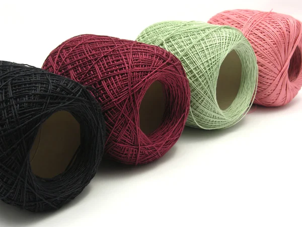 Four balls of wool lying in line on a w — Stock Photo, Image