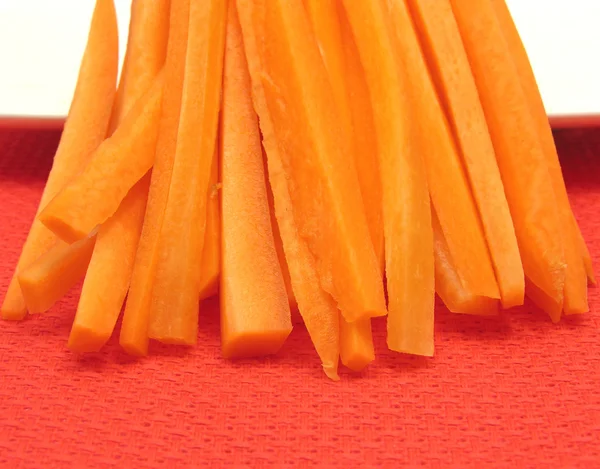 Julienne Karotten auf einem weißen Teller und wieder — Stockfoto