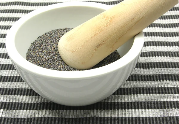 Pestling poppy seeds in a bowl of china — Stock Photo, Image