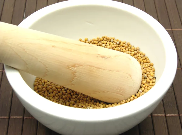 Pestling korrels van mosterd zaad in een bo — Stockfoto