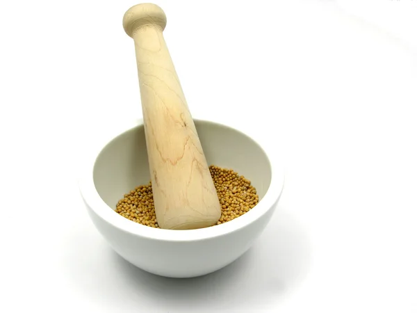 Pestling grains de graines de moutarde dans un bo — Photo