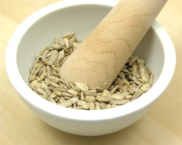 Pestling sunflower seeds in a bowl of ch — Stock Photo, Image