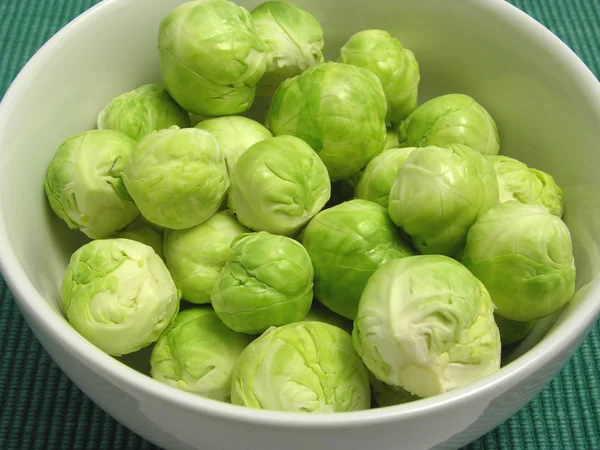 Brussels sprouts in a white bowl and gre — Stock Photo, Image