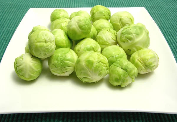 Brussels sprouts arranged on a white pla — Stock Photo, Image