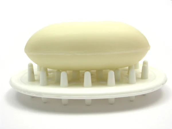 Jabón beige en una jabonera en respaldo blanco —  Fotos de Stock