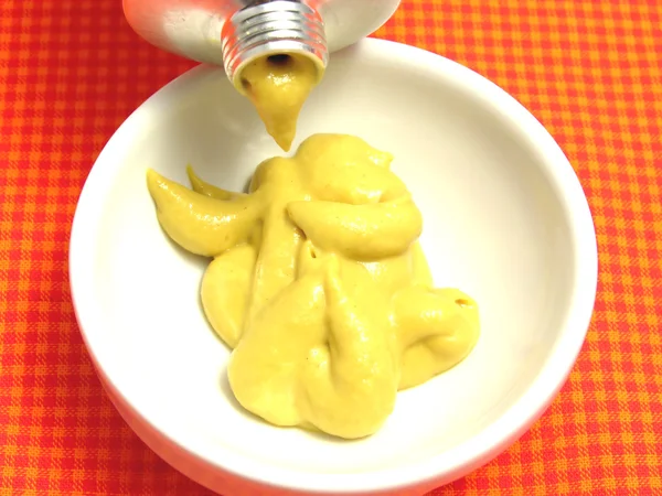 Mustard pressed out of a mustard tube i — Stock Photo, Image