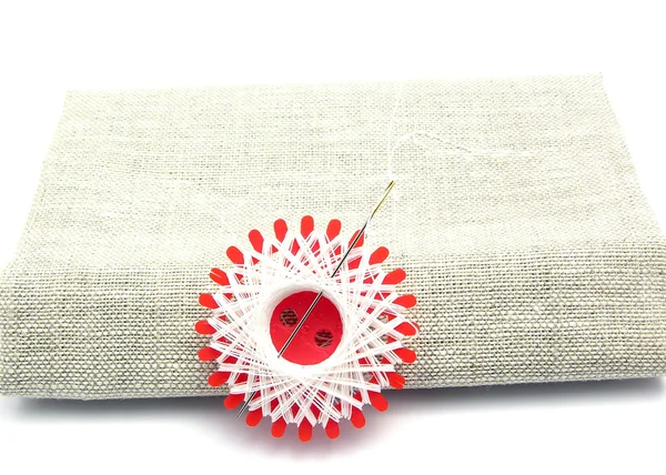 Witte draad met een naai-naald op linon — Stockfoto