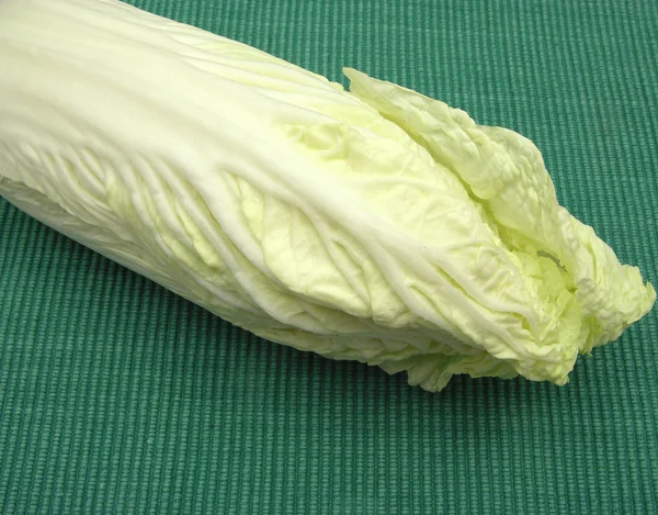 Chinese cabbage on a green rough backgro — Stock Photo, Image
