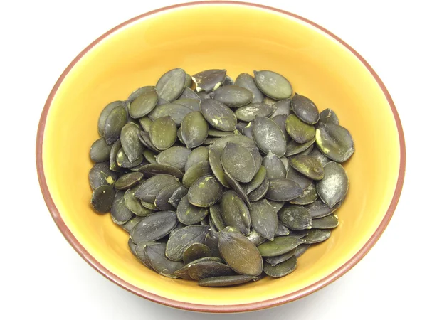 Pumpkin seeds in bowl of ceramic on whit — Stock Photo, Image