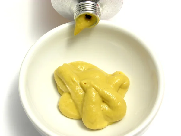 Mustard in a little bowl with mustard tu — Stock Photo, Image