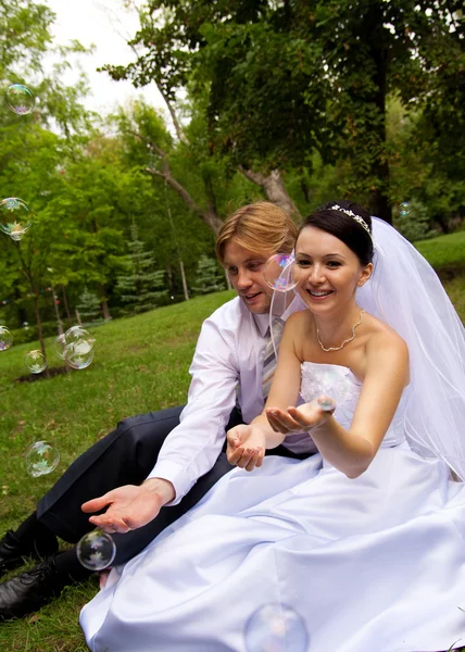 Recém-casados com bolhas de sabão — Fotografia de Stock
