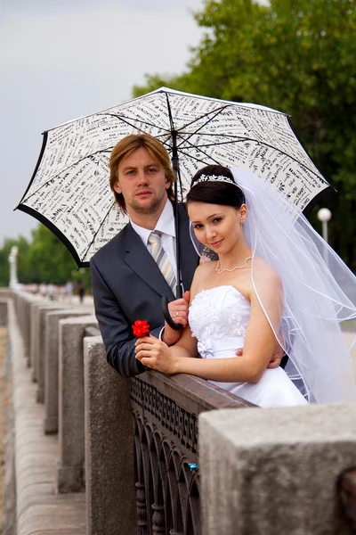 Frischvermählte mit Regenschirm — Stockfoto
