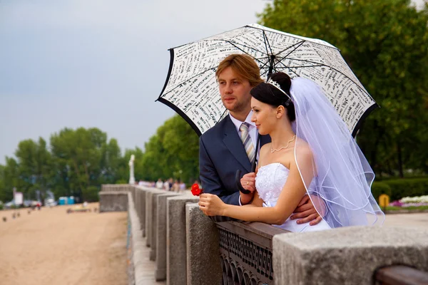 Novomanželé s deštníkem — Stock fotografie