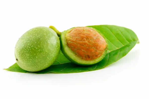 Спелые сломанные орехи с зелеными листьями — стоковое фото
