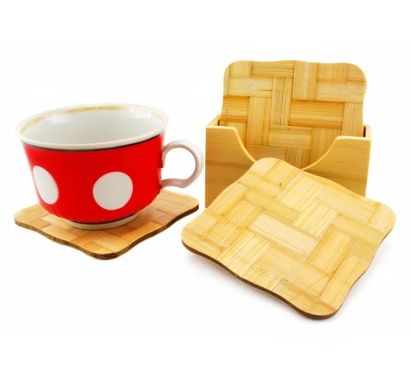 Colored cup and set of wooden trivets — Stock Photo, Image