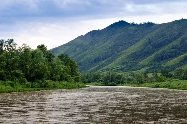 Floden, bergen och mulet himlen — Stockfoto