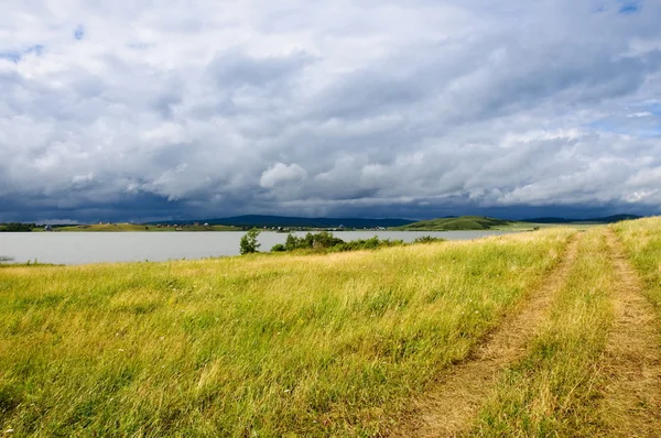 Estrada de campo perto do lago depois de uma chuva — Fotografia de Stock