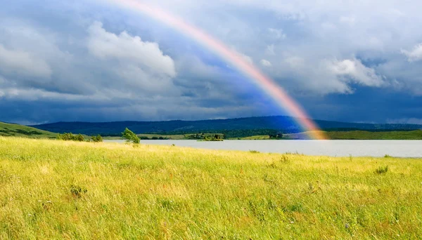 Colors rainbow over lake and fields — Stock Photo, Image