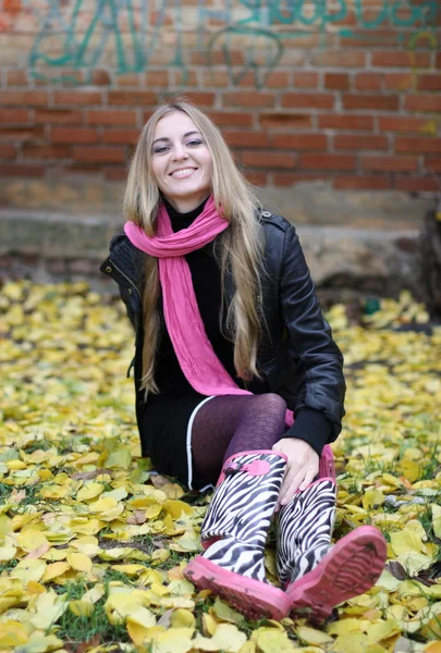 Pigen med det lyserøde tørklæde og støvler - Stock-foto