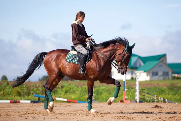 Junges Mädchen reitet auf braunem Pferd — Stockfoto
