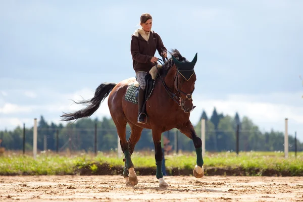 Menina jovem montando no cavalo baía — Fotografia de Stock