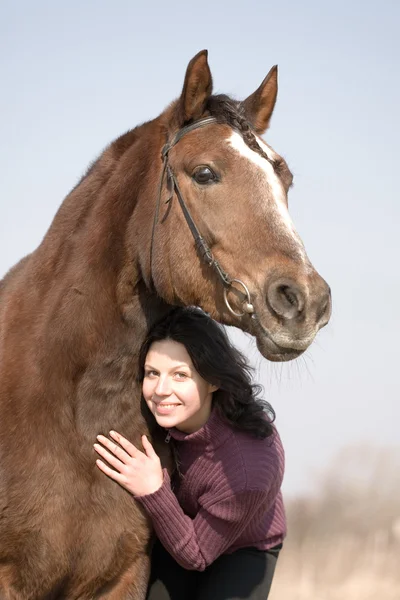 Mladá dívka a kůň v poli — Stock fotografie
