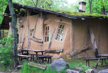 Unusual curve ancient hut in dark wood clipart