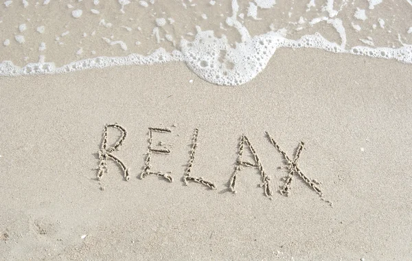 Inscrição Relaxe em uma areia e uma onda — Fotografia de Stock