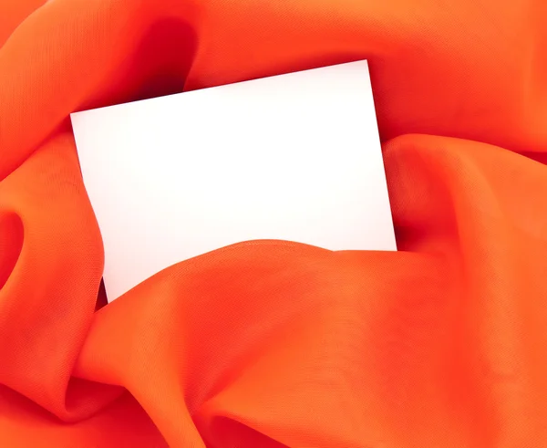 O cartão branco limpo contra a seda vermelha — Fotografia de Stock