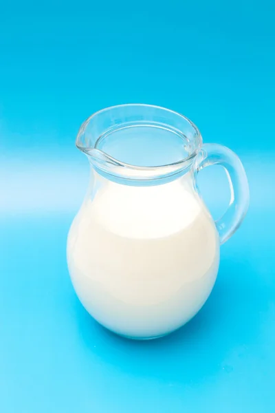 Кувшин молока на синем фоне — стоковое фото