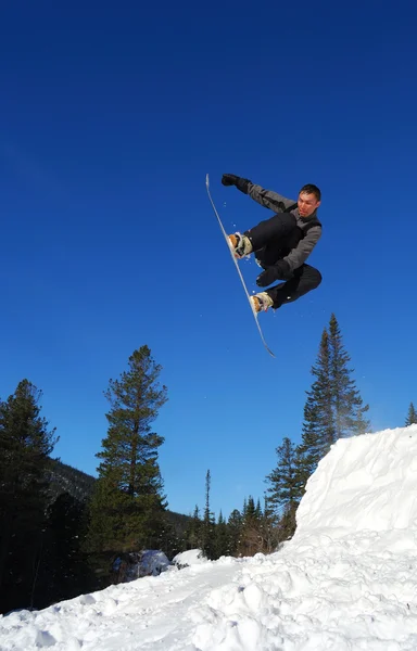 Grauer Snowboarder springt hoch — Stockfoto