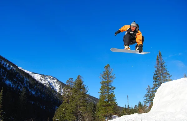 Сноубордист прыгает высоко — стоковое фото