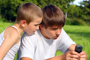 Teenager and kid with mobile phone clipart