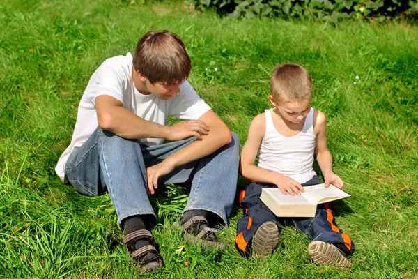 Tiener en kind met een boek — Stockfoto