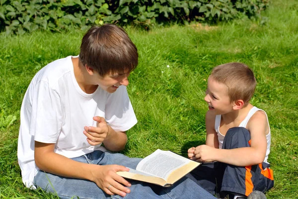 Подросток и ребенок с книгой — стоковое фото