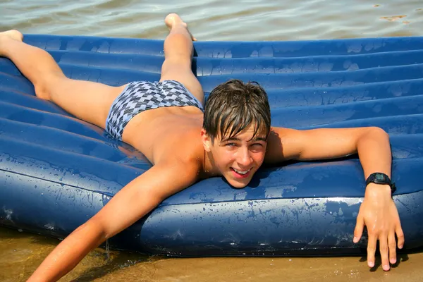 Teenager on beach mattress — Stock Photo, Image