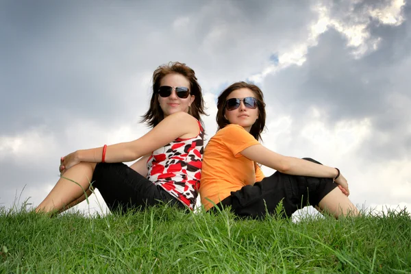 Amigos sentados en la hierba — Foto de Stock