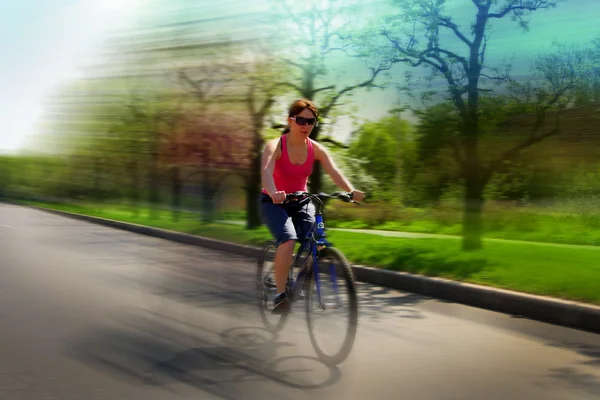 Unga damen kör en cykel Stockfoto