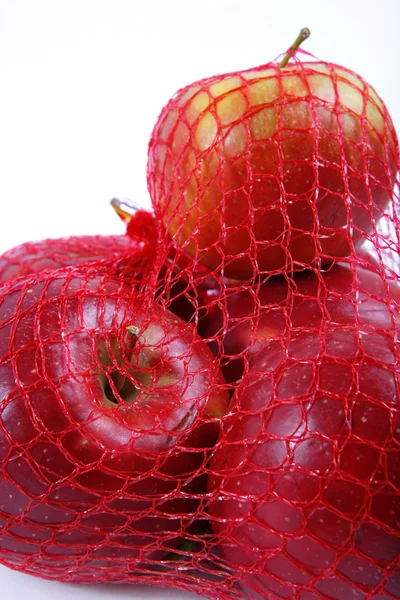 Jabłko w siatce opakowania — Zdjęcie stockowe