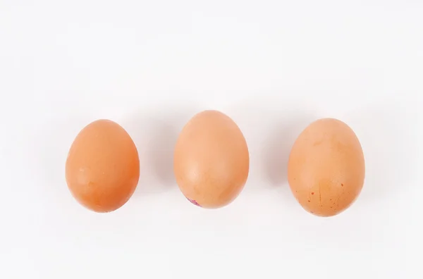 Три яйца на белом фоне — стоковое фото