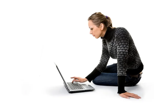 Une fille travaille avec l'ordinateur portable assis sur — Photo